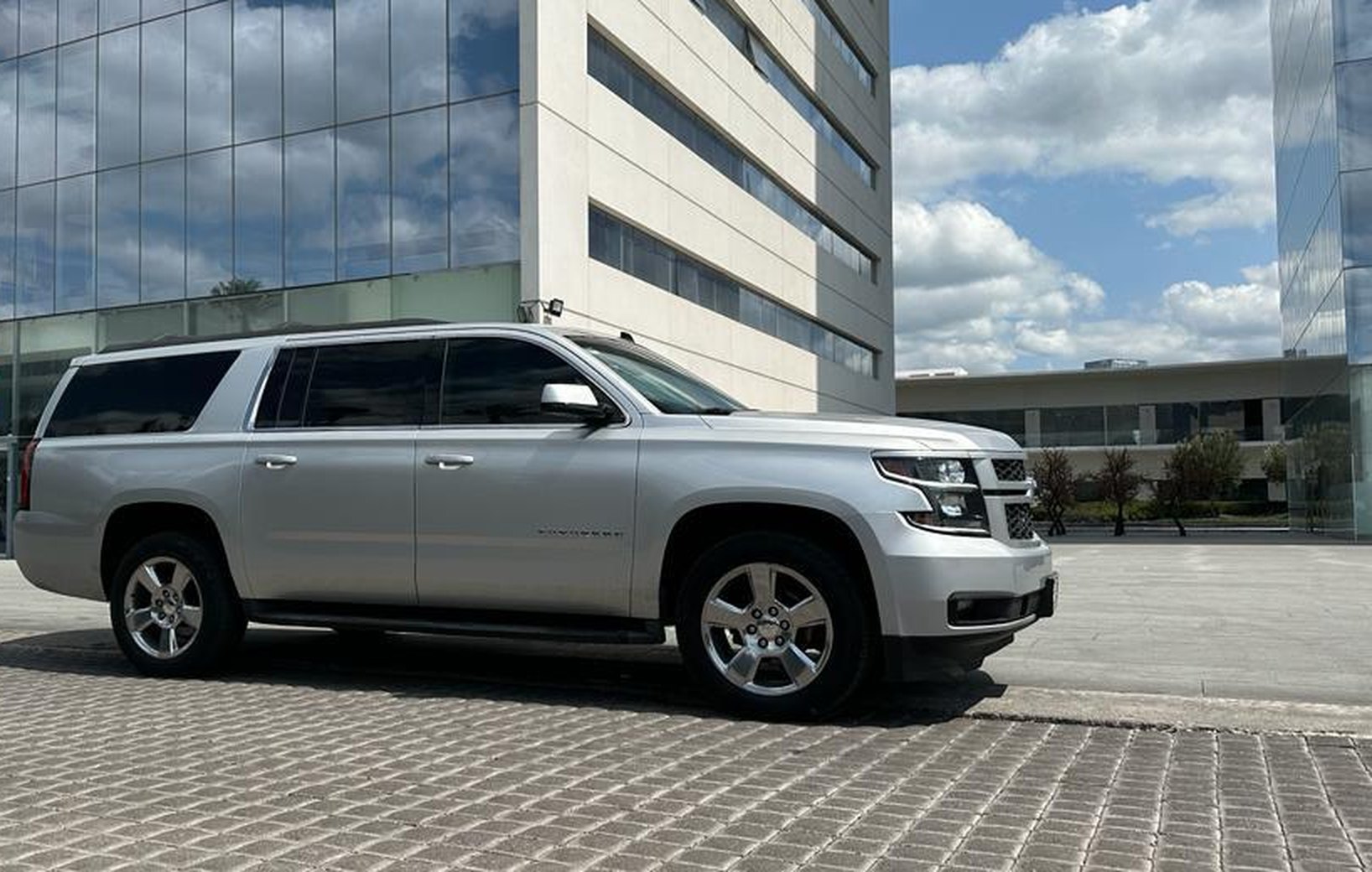 Camioneta Chevrolet Suburban de VVM frente a edificio corporativo